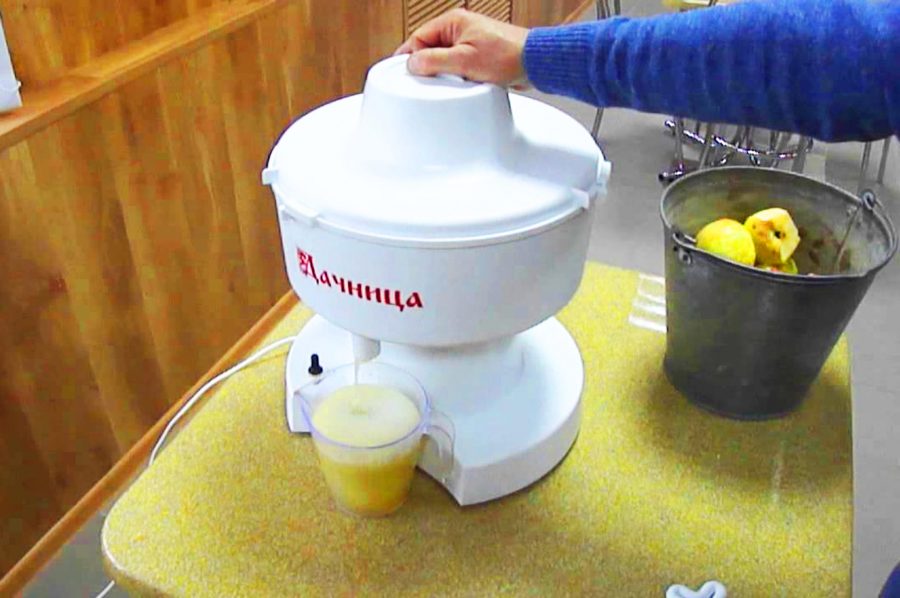 Une femme montre le fonctionnement du préposé à la centrifugeuse.